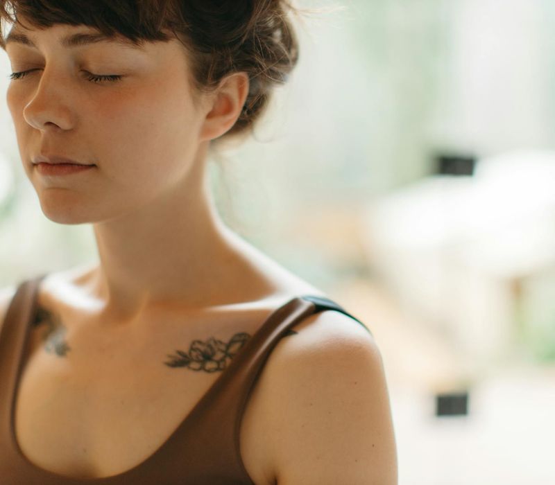Close-up of a person's serene face while breathing deeply.
